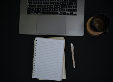 Notebook and Pen on Black Desk