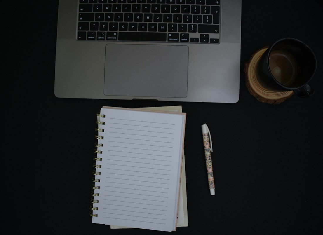 Notebook and Pen on Black Desk