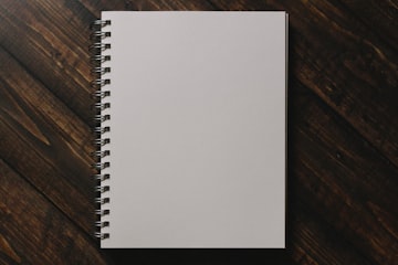 White Spiral Notebook on Wooden Table